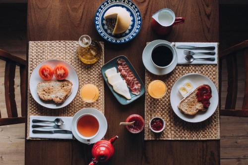 einen Holztisch mit Teller mit Speisen und Tassen Kaffee in der Unterkunft Casa de Santa Uxía in O Ézaro