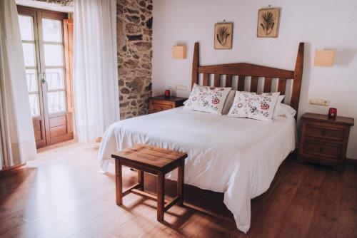 Schlafzimmer mit einem großen Bett mit einem Kopfteil aus Holz in der Unterkunft Casa de Santa Uxía in O Ézaro