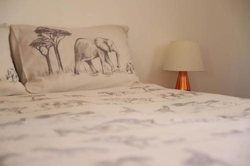 a bed with a pillow with an elephant on it at Butterfly Apartments in Livingstone