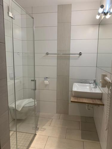 La salle de bains est pourvue d'un lavabo et d'une douche en verre. dans l'établissement Da Yang, à Rankweil