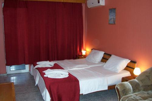 Habitación de hotel con 2 camas y paredes rojas en NELLY Guest House, en Ravda