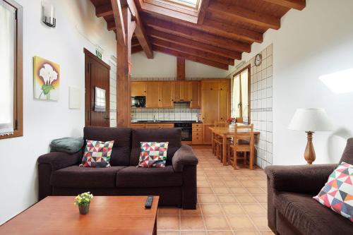 a living room with two couches and a kitchen at Epotx Etxea in Getaria