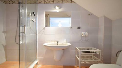 een badkamer met een wastafel en een glazen douche bij Ow Alfa in Rewal