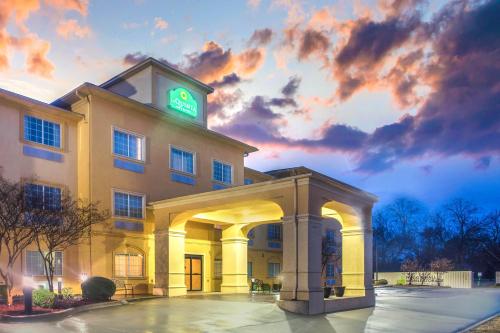 a hotel with a green clock on top of it at La Quinta by Wyndham Fort Smith in Massard