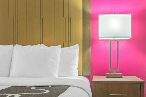 a bedroom with a bed and a lamp on a night stand at La Quinta by Wyndham Fort Smith in Massard