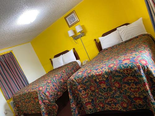 a hotel room with two beds with colorful blankets at Madill Inn in Madill