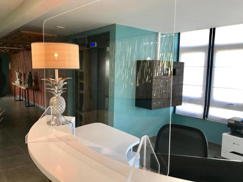 a room with a white table with a vase on it at Diamant les bains - Résidence Hôtelière in Le Diamant