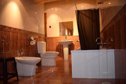 y baño con bañera, aseo y lavamanos. en Apartamentos VIDA Corcubión, en Corcubión
