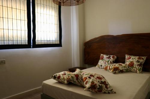 a bed with two pillows on it in a bedroom at Grand Bleu Apartments & Villas in Ermioni