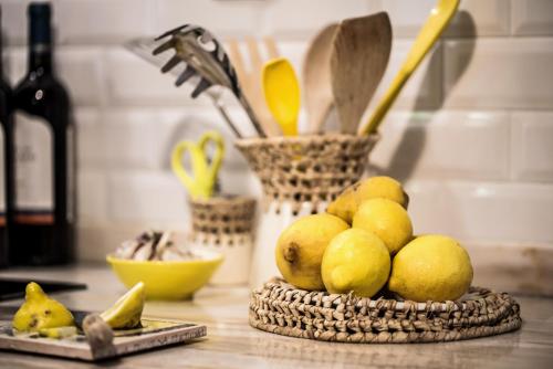a basket of lemons on a counter with a bottle of wine at Lemon Tree Stay in Faro