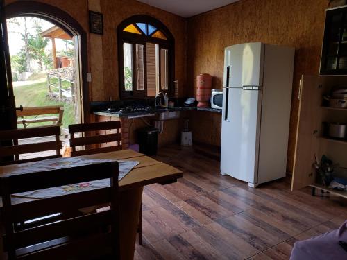 uma cozinha com um frigorífico branco e uma mesa em Chácara Águas Claras em Monte Sião