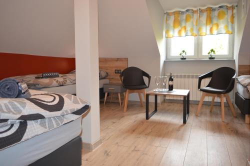 a bedroom with two beds and a table and chairs at Zacisze in Rozalin