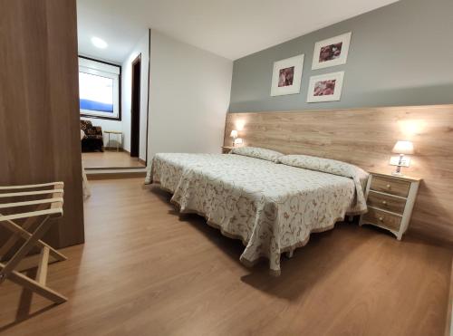 1 dormitorio con cama y cabecero de madera en Hostal-Restaurante Paris, en Forcarei