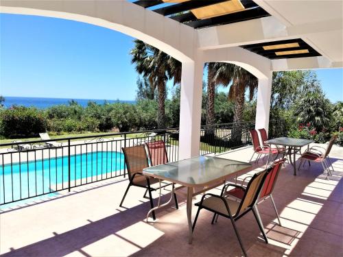 a patio with tables and chairs and a swimming pool at Gabriella in Peyia