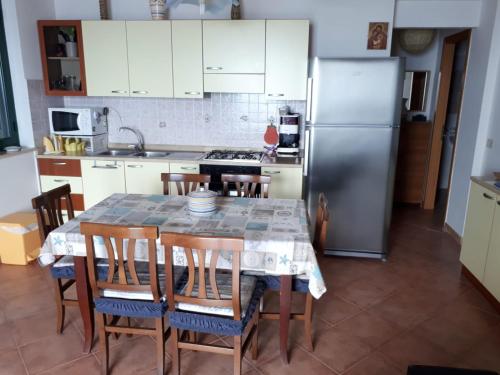 a kitchen with a table with chairs and a refrigerator at Debora in Piraino