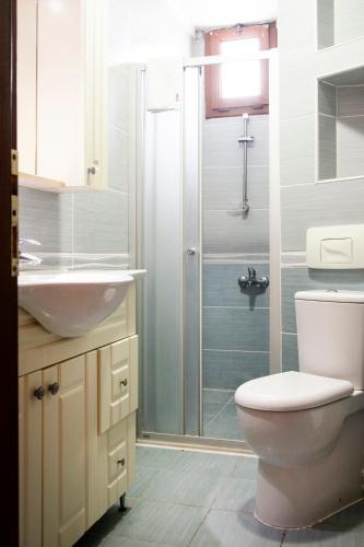 a bathroom with a toilet and a sink and a shower at Beyaz Konak Evleri in Datca