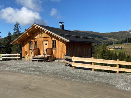 a wooden cabin with a fence in front of it at Jagdhütte in Lachtal