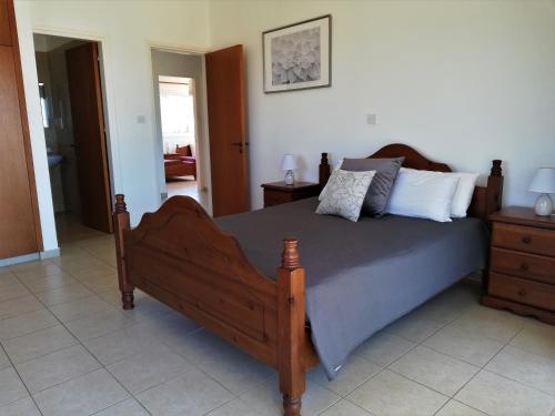 a bedroom with a large wooden bed with white pillows at Gabriella in Peyia