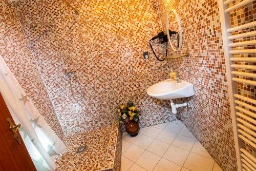 a bathroom with a sink and a tiled wall at Penzion Kozí farma Nový Dvůr in Česká Lípa
