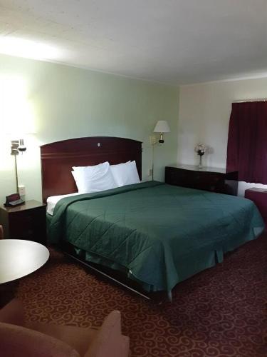 a hotel room with a bed with a green bedspread at WYE Motor Lodge Duncansville - Altoona in Duncansville