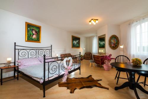 a bedroom with a black bed and a table at Penzion Kozí farma Nový Dvůr in Česká Lípa