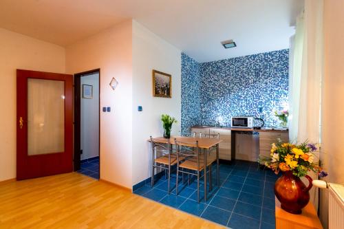 a kitchen with a table and a blue tile wall at Penzion Kozí farma Nový Dvůr in Česká Lípa