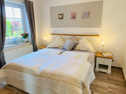 a bedroom with a bed with two night stands and a window at Hasselberger Huus in Hasselberg