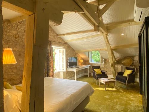 ein Schlafzimmer mit einem Bett und einem Schreibtisch in einem Zimmer in der Unterkunft Le Moulin du Roc in Brantôme