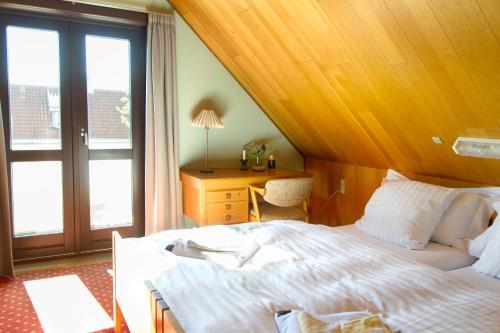 Un dormitorio con una cama y un escritorio y una ventana. en Hotel Inger, en Hulsig