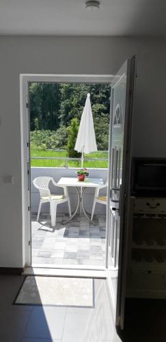 an open door to a patio with a table and umbrella at "Klein & Fein" in Überlingen