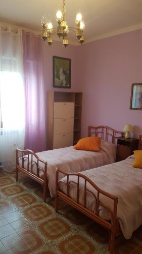 a bedroom with two beds and a window at Le Giarette in Cefalù