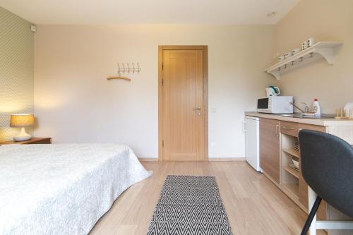 a small room with a bed and a kitchen at Rasos Vila in Palanga