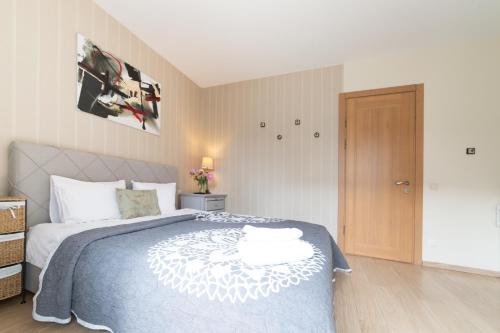 a bedroom with a bed with a blue and white blanket at Rasos Vila in Palanga