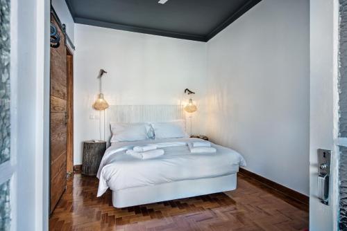 a bedroom with a white bed with two towels on it at Lemon Tree Stay in Faro
