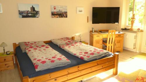 um quarto com uma cama, uma secretária e uma televisão em Sonnengruss am Strand em Eckernförde