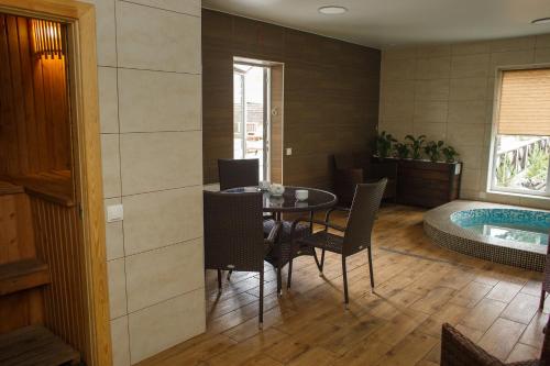 a dining room with a table and a tub at Комплекс На Дачі in Vyshpolʼ