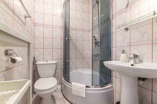 a bathroom with a toilet and a sink and a shower at Pokoje Gościnne Namiastka in Jastrzębia Góra