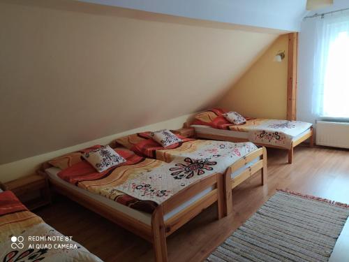 two twin beds in a room with a attic at Noclegi na Wzgórzu Sopotnia Wielka in Sopotnia Wielka