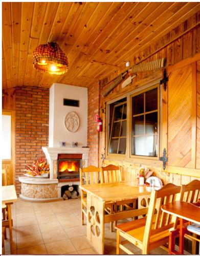 a living room with a table and a fireplace at Karczma Regionalna Młyn -pokoje gościne in Zwierzyniec