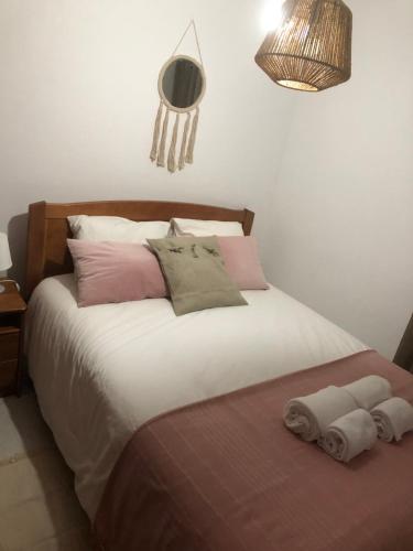 a bedroom with a bed with two towels on it at Casa das Catrinas in Ponte da Barca