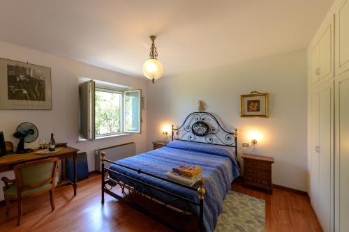 a bedroom with a bed and a desk and a window at Panorami sul Trasimeno in San Feliciano