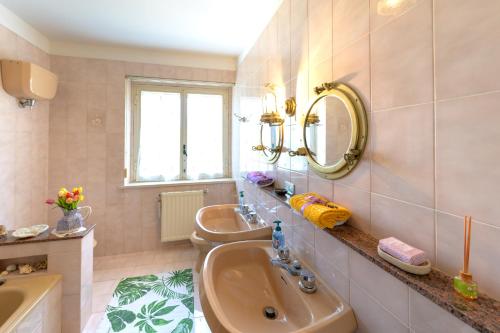 W łazience znajduje się umywalka, toaleta i lustro. w obiekcie Panorami sul Trasimeno w mieście San Feliciano