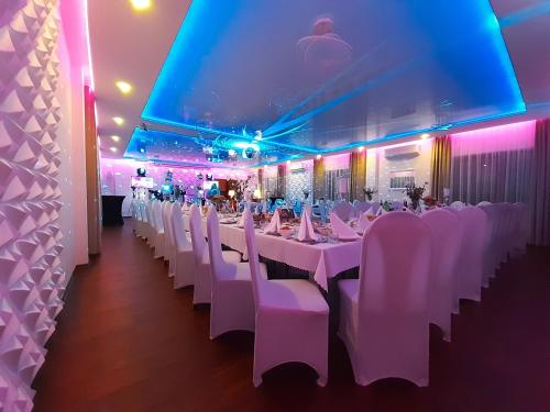 a banquet hall with white tables and white chairs at Route One - Restauracja & Pokoje Hotelowe in Zgierz