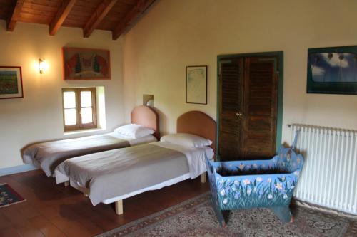a bedroom with two beds and a chair in it at Agriturismo La Rovere in Cossano Belbo