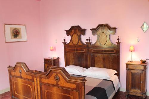 a bedroom with a large wooden bed with white pillows at Agriturismo La Rovere in Cossano Belbo
