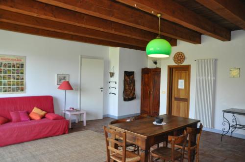a living room with a red couch and a table at Agriturismo La Rovere in Cossano Belbo
