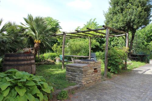 a wooden pergola with a picnic table in a garden at Agriturismo La Rovere in Cossano Belbo