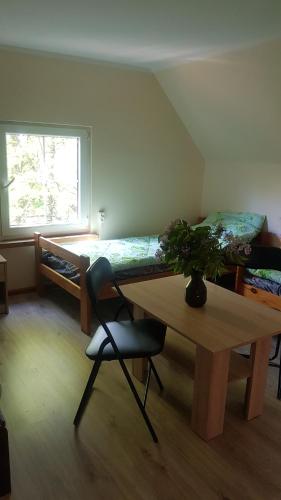 a room with a table and a bed with a plant at Zacisze in Kukle