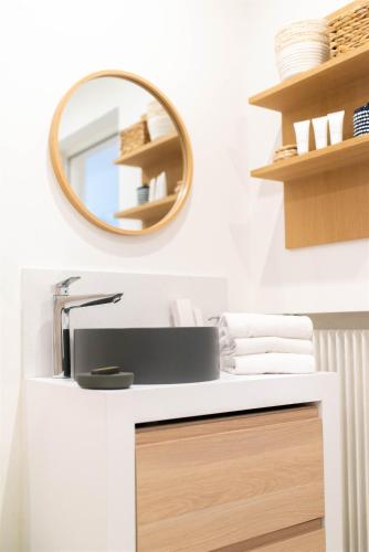 une salle de bain avec un lavabo et un miroir dans l'établissement LA Villa Du Lac, à Annecy