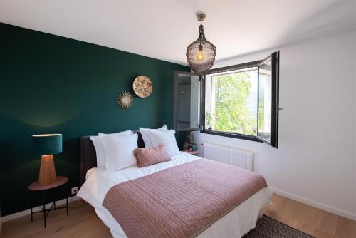 ein Schlafzimmer mit einem Bett und einer grünen Wand in der Unterkunft LA Villa Du Lac in Annecy
